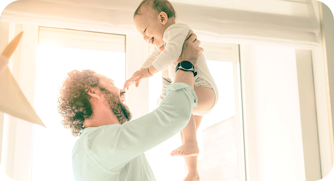 father holding happy baby up in air