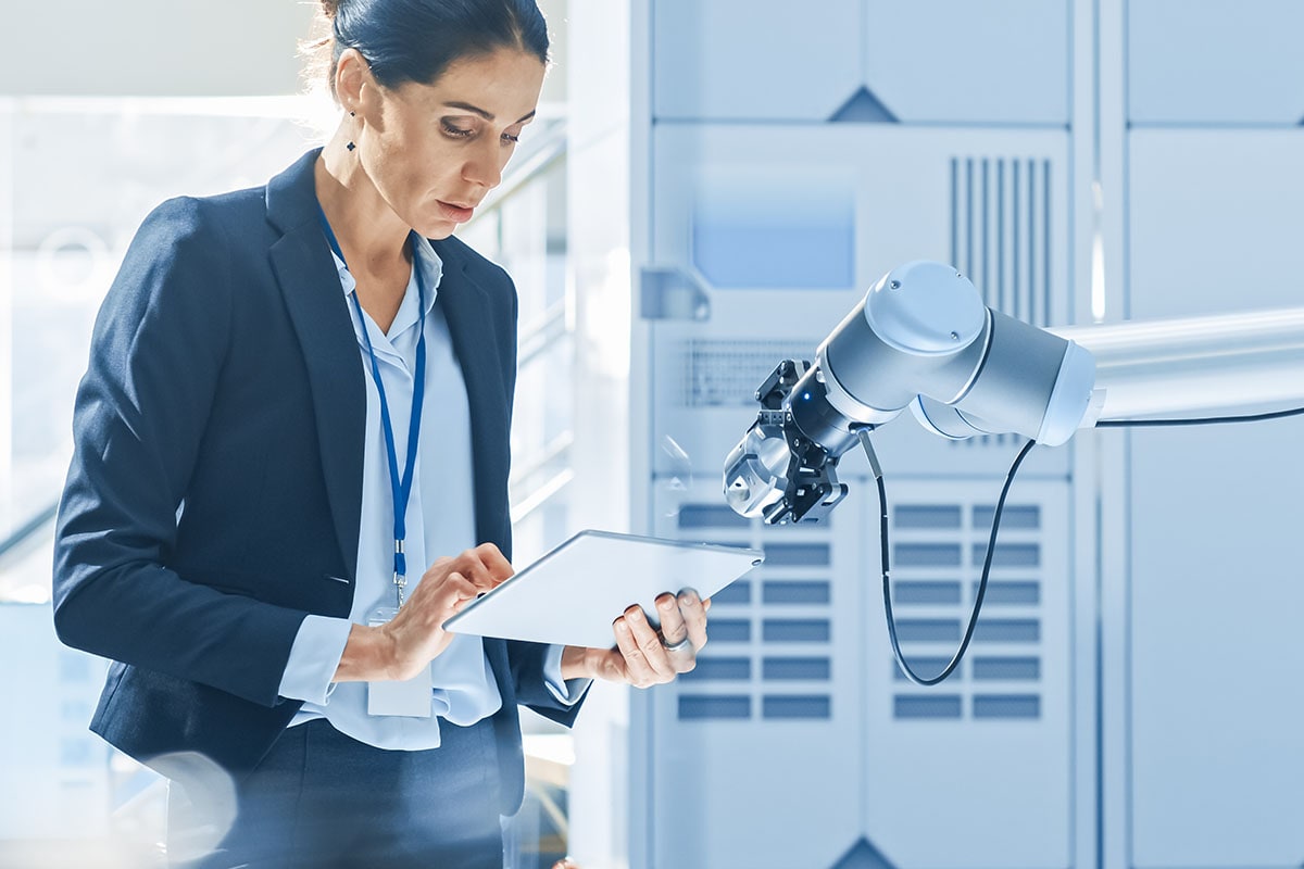 Woman with Ipad taking notes near surgical robot